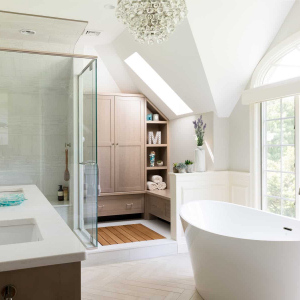 RELAXING RETREAT MASTER BATH-A custom drying space outside the shower is flooded with light from a new skylight. It features an inset white oak drainable drying platform surrounded by custom cabinetry, including a built-in bench and linen closet.