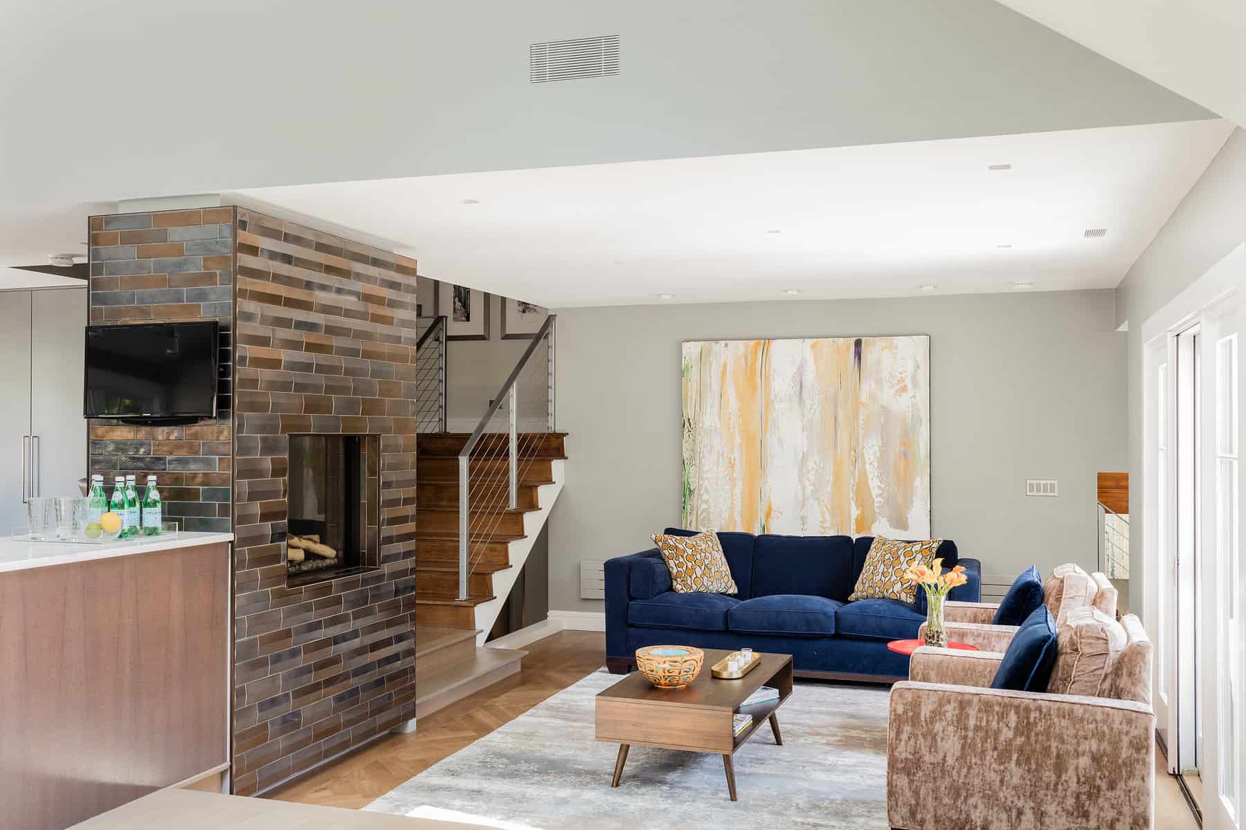After: Living room view toward stairs-the open concept floor plan showcases a collection of contemporary art.
