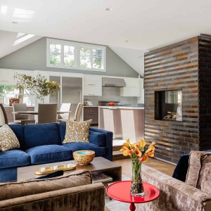 After: Living Room towards Dining Room-The original fireplace was  replaced with a two-sided gas fireplace clad with handmade ceramic tiles.