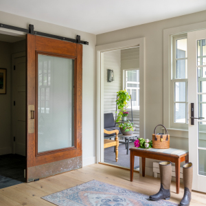 Reclaimed sliding doors separate the kitchen from new mudroom. Beyond is the screened-in porch.