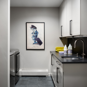 Laundry room received a refresh with new cabinet paint, countertops, hardware, and fixtures that coordinate with the kitchen materials