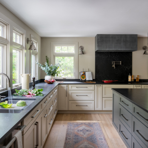 View towards back of kitchen. The custom cooktop hood features an aged acid washed zinc finish with a modern profile. 