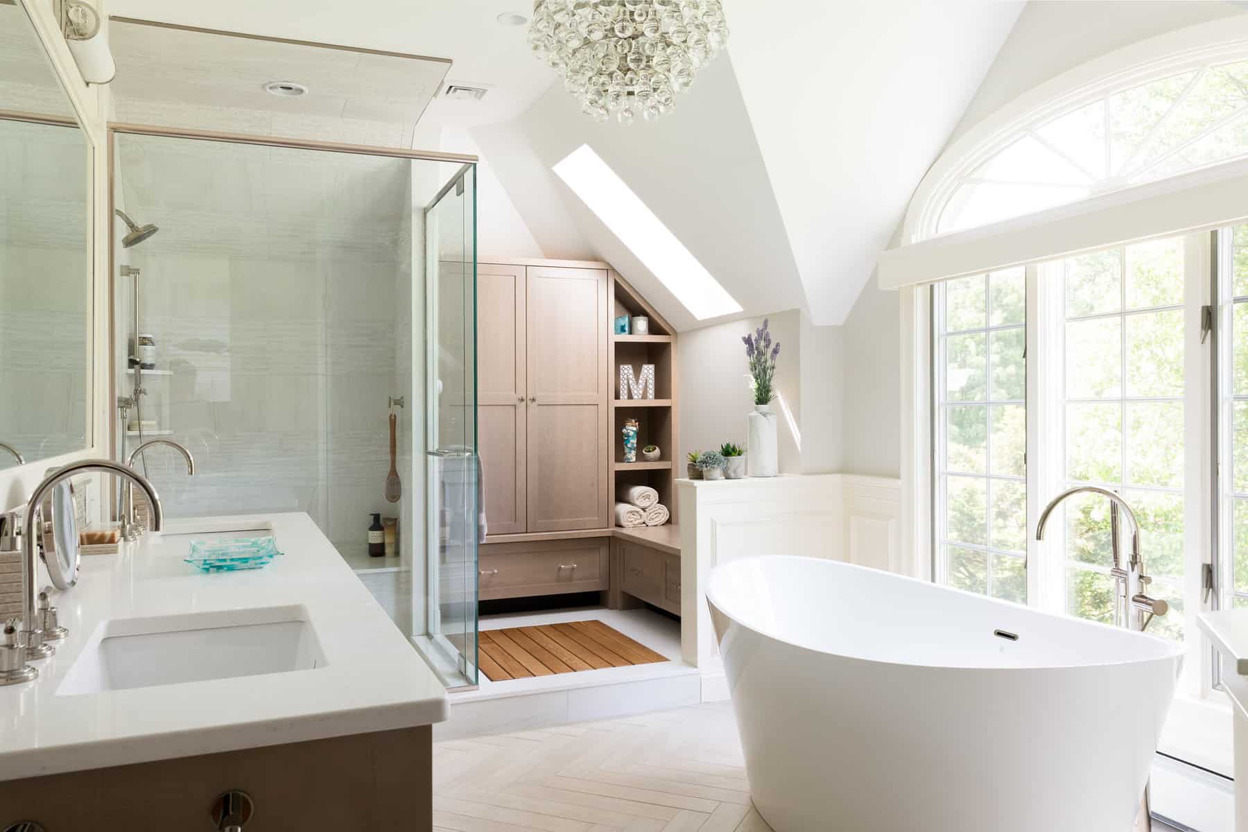 RELAXING RETREAT MASTER BATH-A custom drying space outside the shower is flooded with light from a new skylight. It features an inset white oak drainable drying platform surrounded by custom cabinetry, including a built-in bench and linen closet.