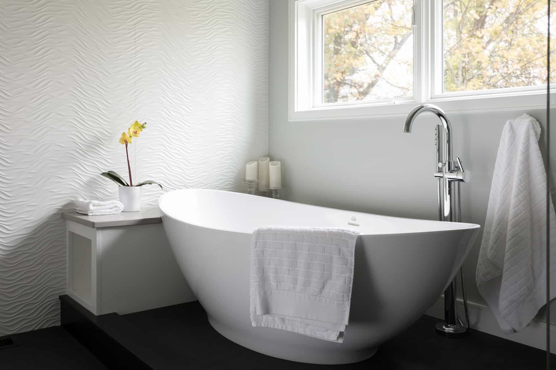 ANDOVER TOWNHOUSE BATH-The wave theme is repeated with the wave white porcelanosa tile wall alongside the tub. An elevated tub deck doubles as a drying platform outside of shower. The innovative Link floor tile features a vinyl top above a pvc base which prevents water absorption. 2017 Designer Bath Shine award for best spa bath.