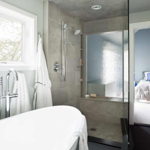 ANDOVER TOWNHOUSE MASTER BATH-The wavevue glass in the shower window and pocket door create a transparent and architecturally interesting connection between the bath and master bedroom, while still allowing for privacy. 2017 Designer Bath Shine award for best spa bath.