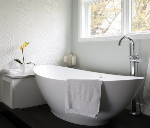 ANDOVER TOWNHOUSE BATH-The wave theme is repeated with the wave white porcelanosa tile wall alongside the tub. An elevated tub deck doubles as a drying platform outside of shower. The innovative Link floor tile features a vinyl top above a pvc base which prevents water absorption. 2017 Designer Bath Shine award for best spa bath.