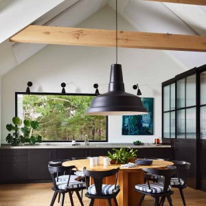 A mammoth factory light illuminates the breakfast table; The industrial theme is repeated with concrete counters.