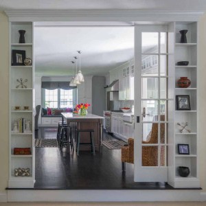 Entrance from family room to kitchen was transformed with an over-sized French glass pocket door and integrated niche cabinets to display artwork.