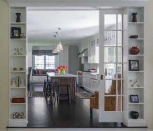 Entrance from family room to kitchen was transformed with an over-sized French glass pocket door and integrated niche cabinets to display artwork.