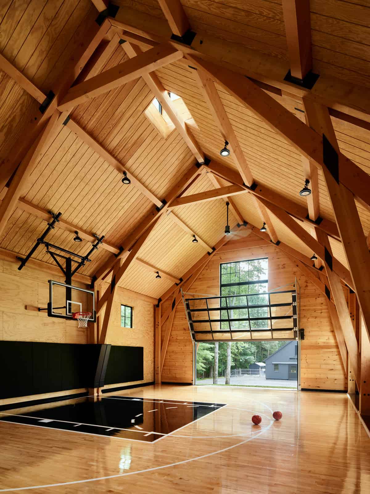 The structural Douglas Fir timber frame is economical in design. While the frame supports a volume of space large enough to shoot a basketball from any angle, it uses smaller dimensioned timber sizes in a carefully thought-out design  that makes efficient use of the timber to structurally support such a large space.
