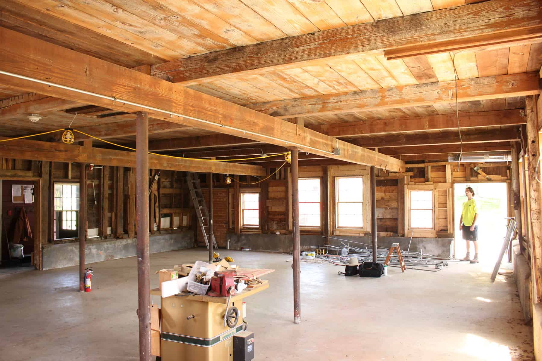 BEFORE: 1793 Barn Interior--Although the barn had a plywood ceiling from a previous renovation, a "hint" of timber-frame was exposed. The surprise discovered behind the ceiling was an expansive timber frame - oak tie beams that were 30' long, telltale hand tool marks, and other timber frame elements that indicated the barn predated 1800. (photo by Benjamin Nutter Architects)