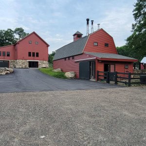 The bull barn was located in front of the 1793 barn. The bull stalls were removed and the building was converted to a maple sugaring facility. A traditional color palette was used to paint the buildings and fences to maintain the historical ambiance of the property.