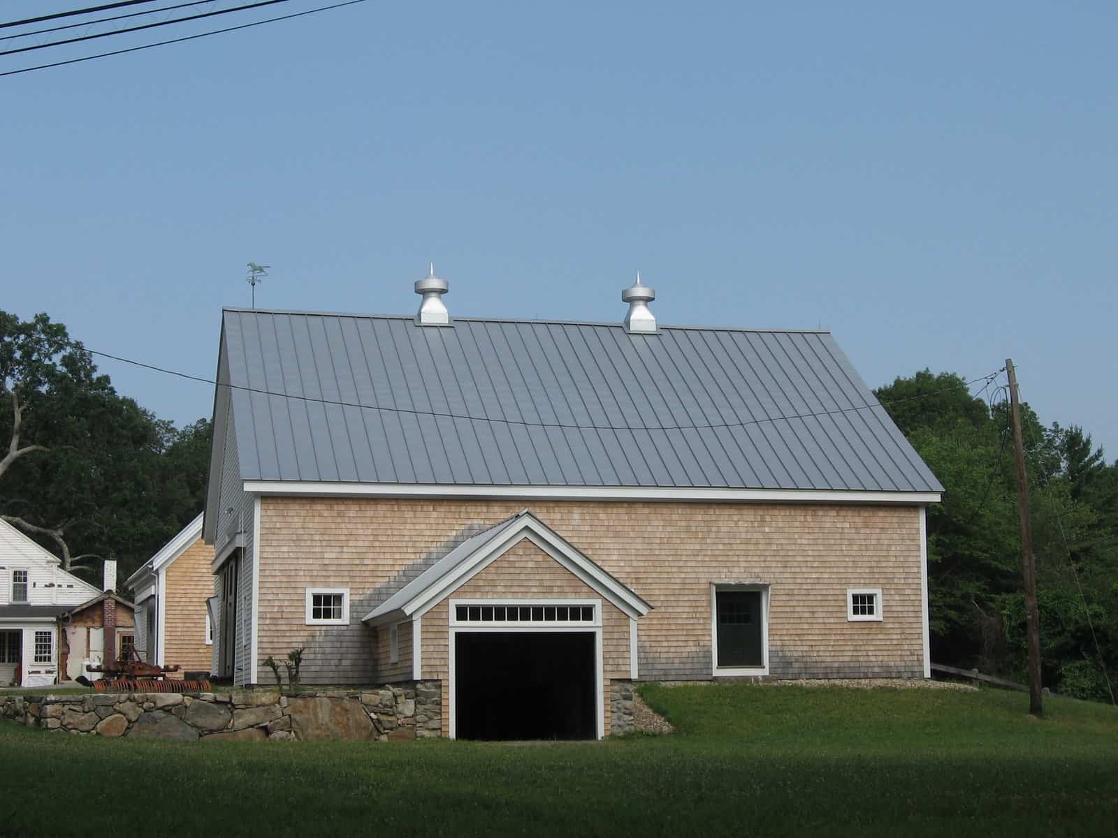 A newly constructed covered side entry on the restored barn  demonstrates how well the new work blends in with the old, especially the stone work.