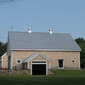 A newly constructed covered side entry on the restored barn  demonstrates how well the new work blends in with the old, especially the stone work.