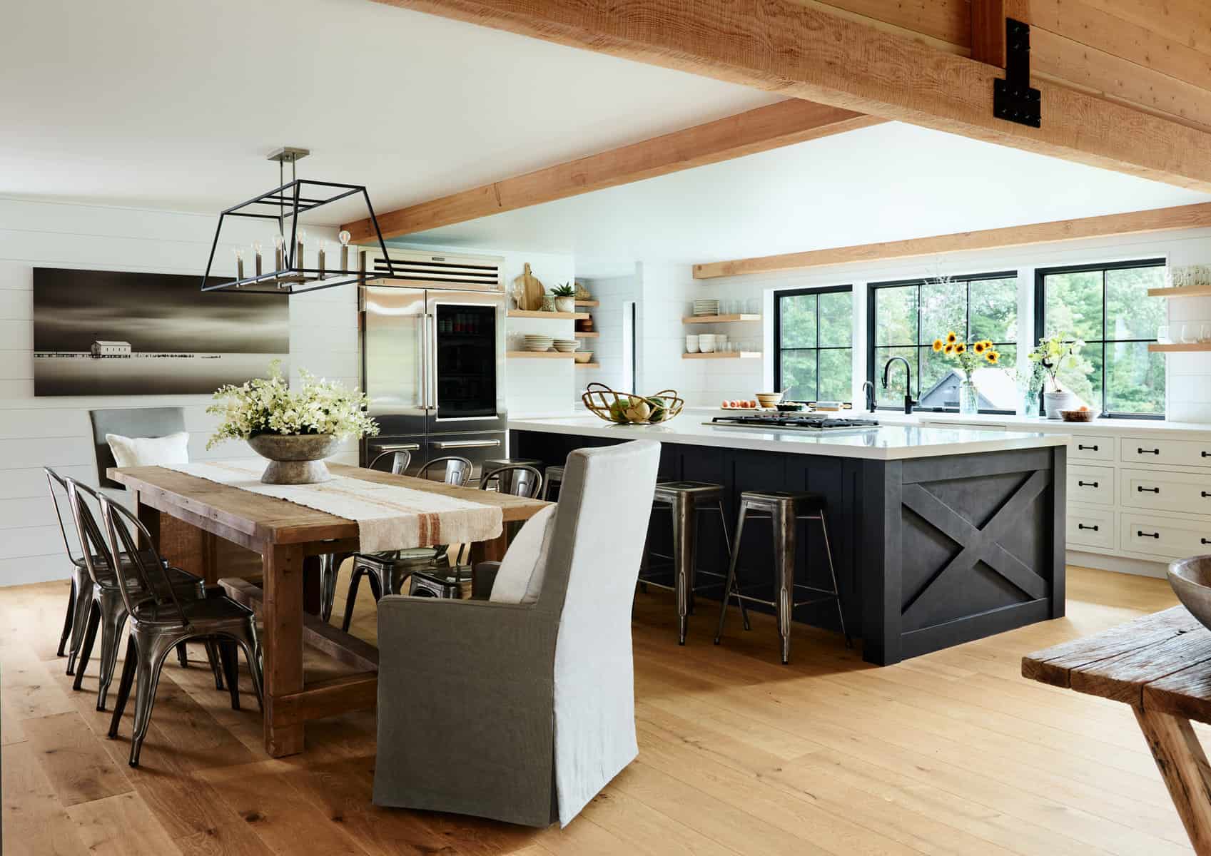 The kitchen island has a unique finish of black suede paint, playing off the metal joinery on the timbers.Decorative ceiling timbers were added, carrying the idea of the living room timber frame to this space.
