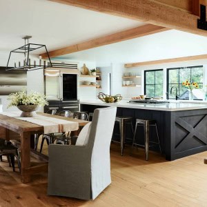 The kitchen island has a unique finish of black suede paint, playing off the metal joinery on the timbers.Decorative ceiling timbers were added, carrying the idea of the living room timber frame to this space.