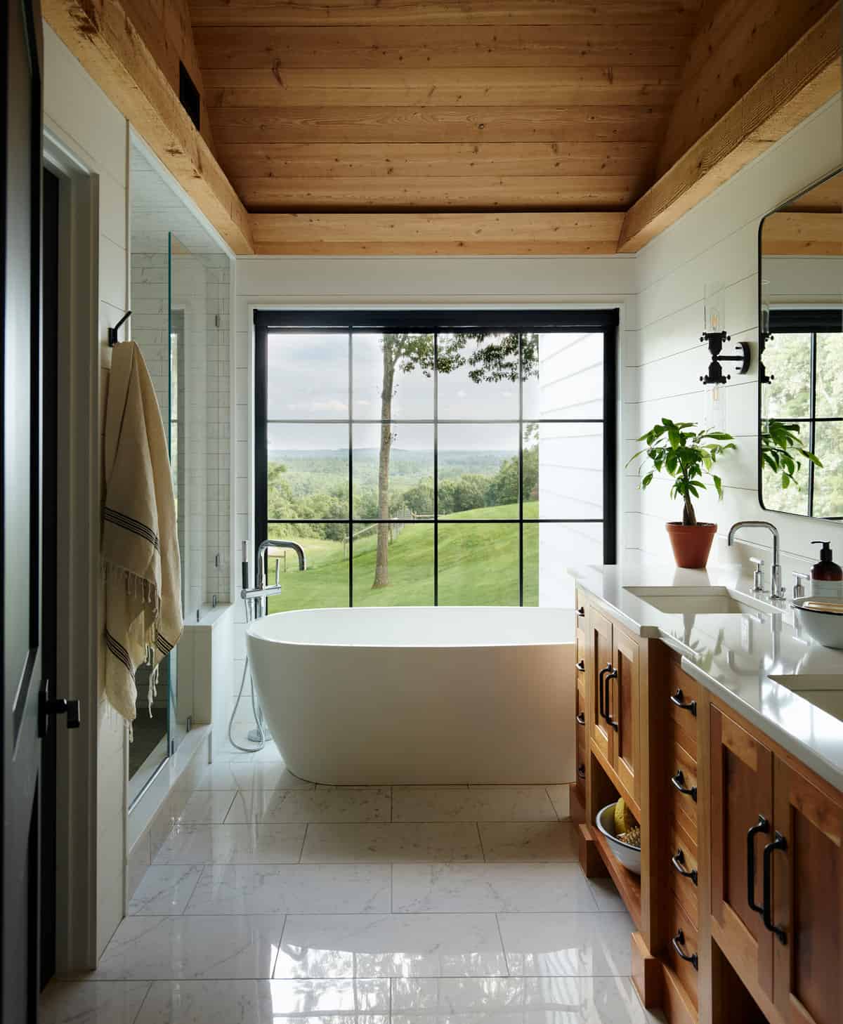 22-Master-Bath-AFTER. All fixtures, except the vanity, were rearranged. A separate water closet was created. A new vaulted, wood paneled ceiling lightens, yet warms, the space.  A floor to ceiling feature window frames the view.