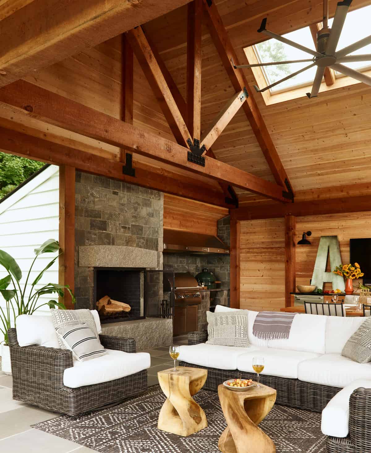 26-New-Additon-Outdoor-Room-Seating-Area.The room is framed with an exposed Douglas Fir timber frame, which is both structural and decorative, and matches the frame in the adjacent family room. The result is a rustic yet modern, beautiful outdoor space that provides an exquisite transition between the indoors and the outdoors.