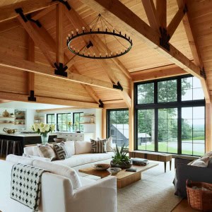 10-View-towards-kitchen-AFTER-A transitional Douglas Fir timber frame, which is both structural and decorative, was added to the family room . With it’s rough-sawn face, it combines traditional mortise & tenon joinery with more current black iron connecting plates. The result is rustic, yet sophisticated, adding warmth and stunning architectural detail to the home.