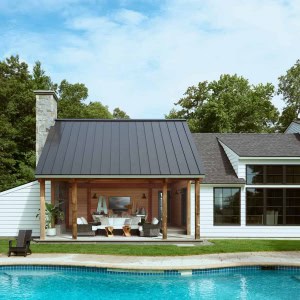 23-New-Addition-Outdoor-Room-Exterior. The goal was to create a fluid living space that flowed with the pool, took advantage of the views, and could be used for entertaining, dining, as well as reading, sitting by the fireplace, watching the kids in the pool, or just staring at the views.