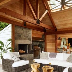 26-New-Additon-Outdoor-Room-Seating-Area.The room is framed with an exposed Douglas Fir timber frame, which is both structural and decorative, and matches the frame in the adjacent family room. The result is a rustic yet modern, beautiful outdoor space that provides an exquisite transition between the indoors and the outdoors.