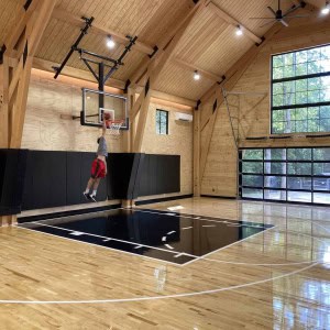 30-Fieldhouse-Barn-Dunk-– The fieldhouse features a collegiate quality maple hardwood gymnasium floor, and a standard tempered glass and aluminum garage door that is large enough for great views and cars (giving the space future flexibilty as a  car barn).