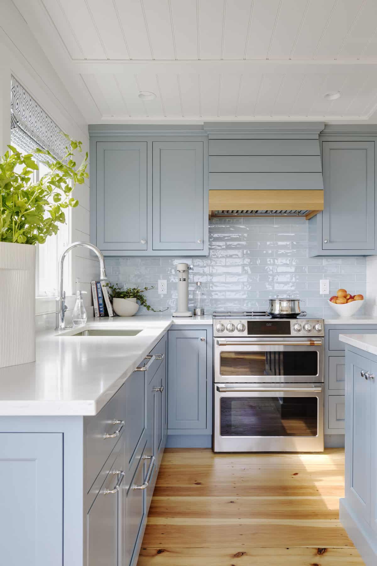Lighter stone countertops and new shaker style blue cabinets offer a modern, subdued feel.