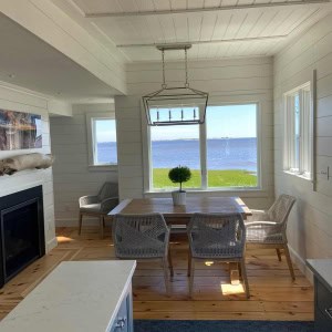 View from Kitchen to Dining Area-A visual connection between the first-floor spaces was created by removing walls and using detailed moldings, shiplap wall paneling, and beadboard ceiling paneling throughout.