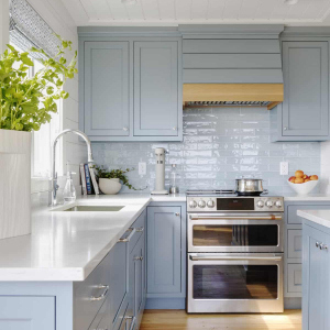 Lighter stone countertops and new shaker style blue cabinets offer a modern, subdued feel.