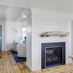 A double-sided fireplace replaced a solid wall between the living room and dining room.  The Dining Room mantle is a piece of driftwood the homeowner found on a morning beach walk on Plum Island.