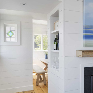The new fireplace is a walk-around, with built-in bookshelves and a cabinet tucked away at one end, maximizing storage in this small space. Natural light now streams into the entire first floor.