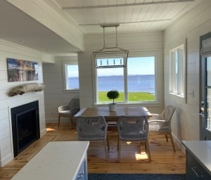 View from Kitchen to Dining Area-A visual connection between the first-floor spaces was created by removing walls and using detailed moldings, shiplap wall paneling, and beadboard ceiling paneling throughout.