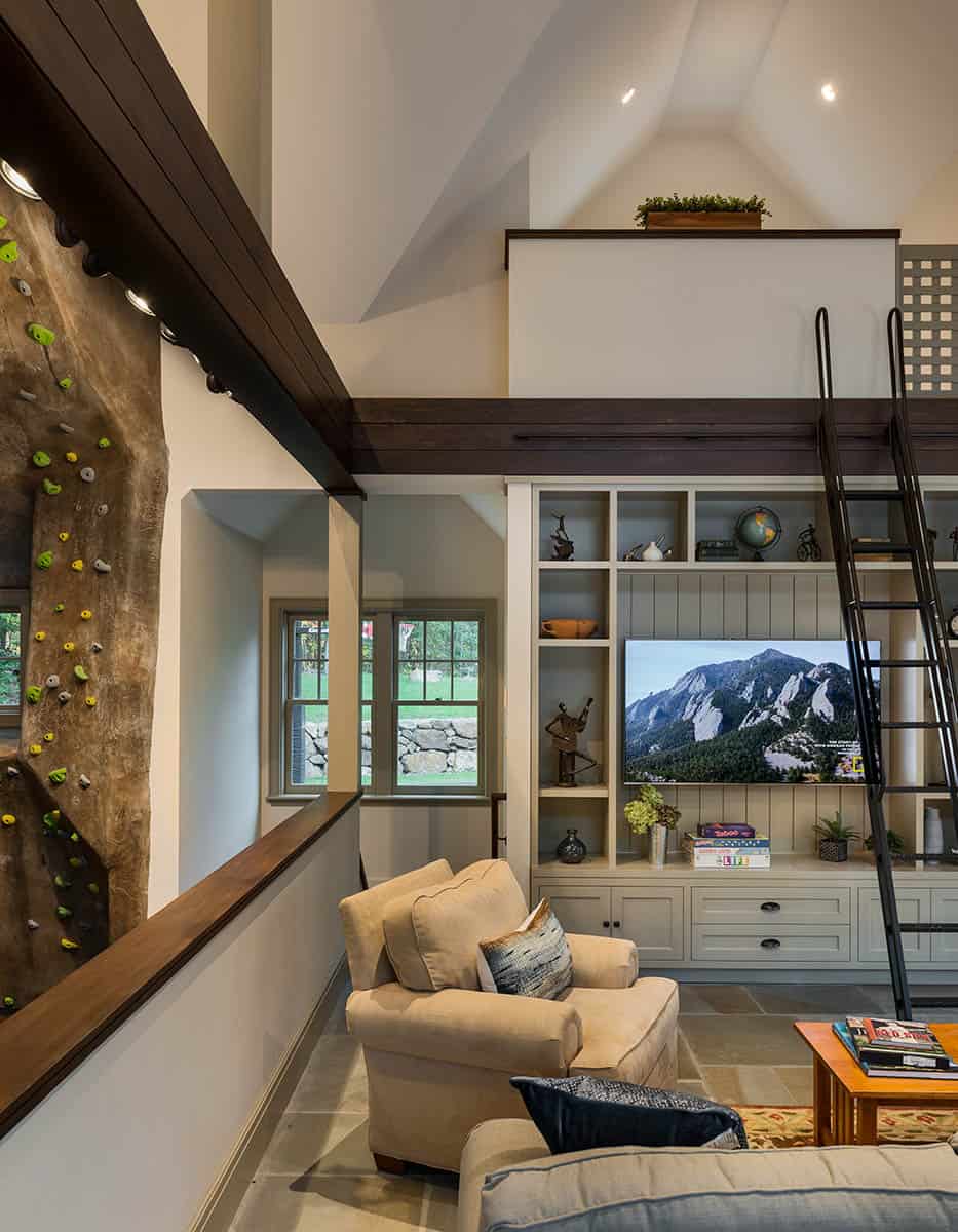 The living space overlooks the climbing wall, and a sleeping loft above overlooks the living space.