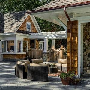Outdoor sitting area with view towards poolhouse. Note the fully retractable bi-fold windows in poolhouse kitchen to allowing for easy  poolside service.