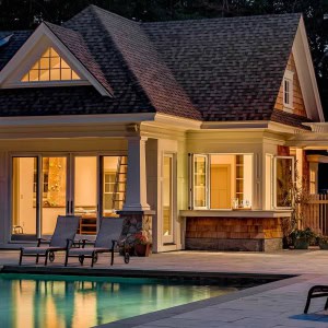 Poolhouse at night with view of indoor climbing  wall through sliders.