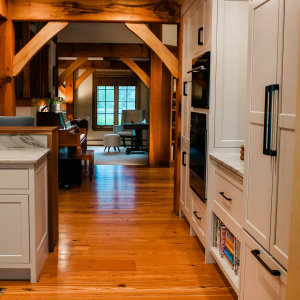Boxford, MA Timber frame -view from  kitchen to family room highlights timber frame's symmetry