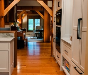Boxford, MA Timber frame -view from  kitchen to family room highlights timber frame's symmetry